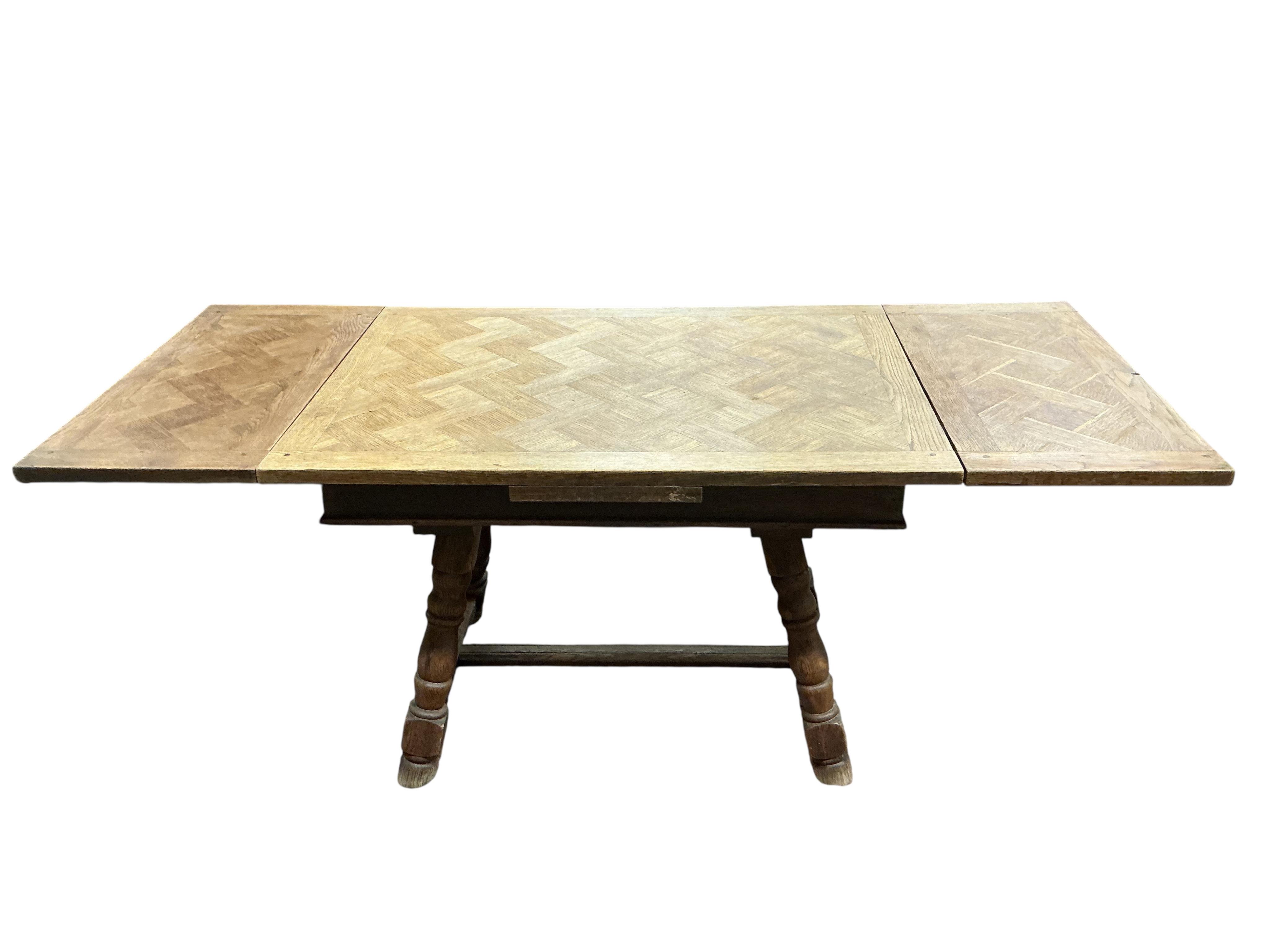 A small late 19th / early 20th century French parquetry oak draw leaf dining table, width 186cm extended, depth 79cm, height 74cm